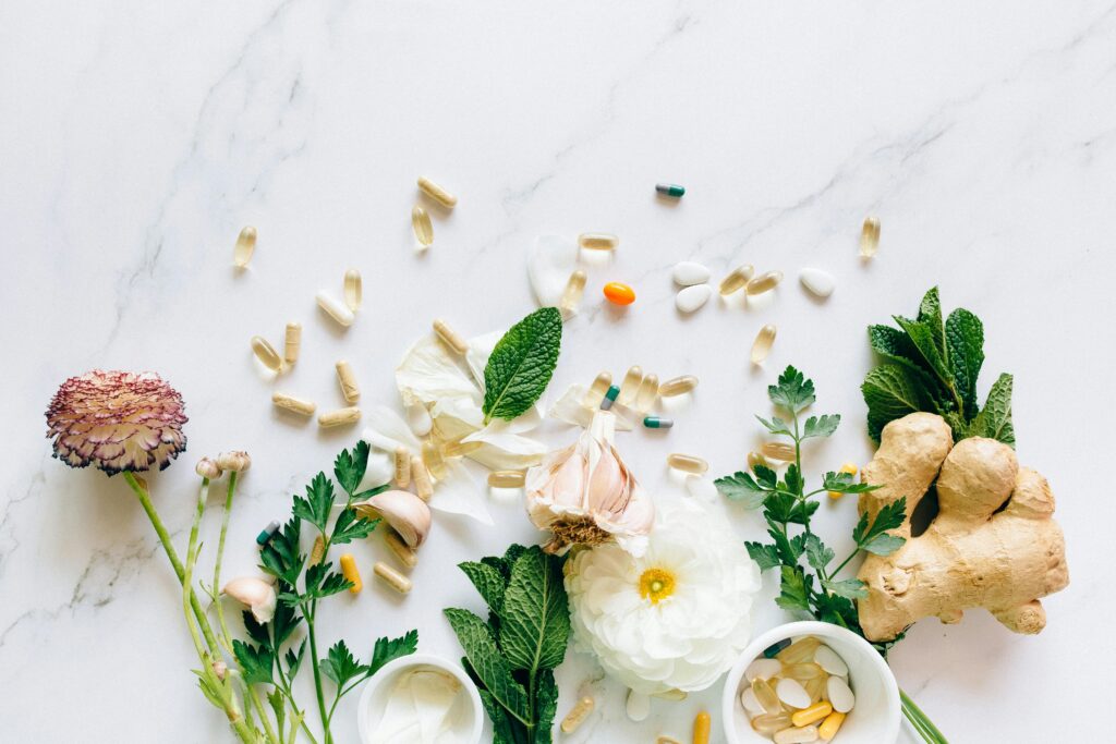 Natural herbs and pills arranged on a marble surface for a holistic healthcare theme.