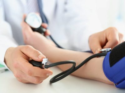 Close-up of doctor check blood pressure of patient in clinic, risk of hypertension, prevent disease. Work with stethoscope tool. Medicine, health concept
